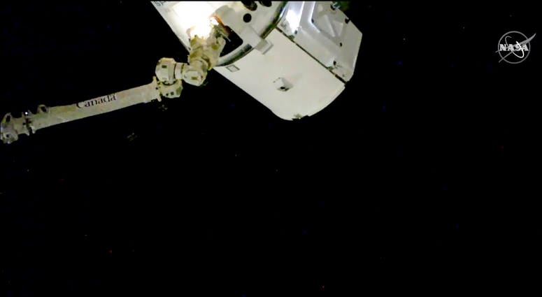 In this image taken from NASA Television, the SpaceX Dragon cargo spacecraft is captured by a robotic arm for docking to the International Space Station, Saturday, Dec. 8, 2018. In this image taken from NASA Television, the SpaceX Dragon cargo spacecraft is captured by a robotic arm for docking to the International Space Station, Saturday, Dec. 8, 2018.