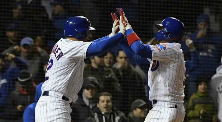 Chicago Cubs second baseman Javier Baez (9), right, high-fives Chicago Cubs left fielder Kyle Schwarber (12) after they score on Baez's two run home run against the St. Louis Cardinal