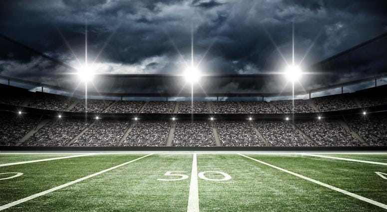 A football field under stadium lights