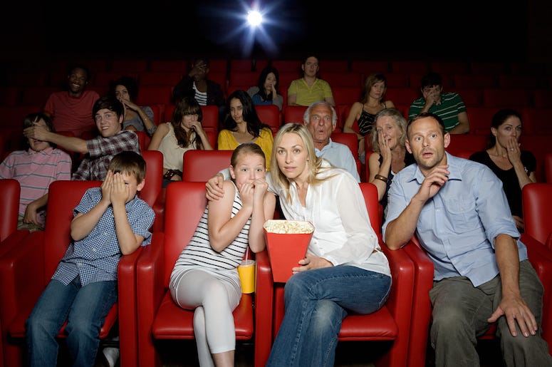 A family enjoys a movie in a theater A family enjoys a movie in a theater