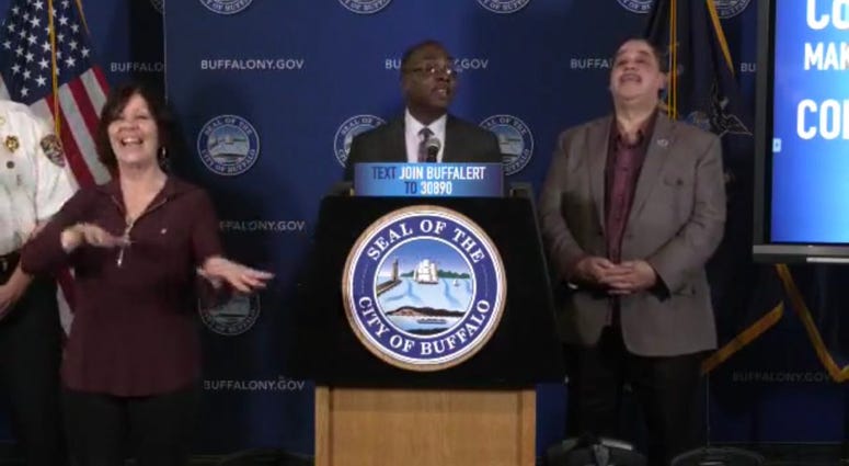 Karen Gambino (left) provides sign language interpreting during Mayor Byron Brown's March 17 press conference. In this moment, Mayor Brown encouraged Buffalonians to celebrate Tom Brady leaving New England. March 28, 2020 (Photo via Mayor Brown Facebook) Karen Gambino (left) provides sign language interpreting during Mayor Byron Brown's March 17 press conference. In this moment, Mayor Brown encouraged Buffalonians to celebrate Tom Brady leaving New England. March 28, 2020 (Photo via Mayor Brown Facebook)