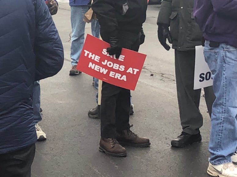 Protesters gather outside the New Era plant in Derby to protest the company's decision to lay off workers and move manufacturing elsewhere.