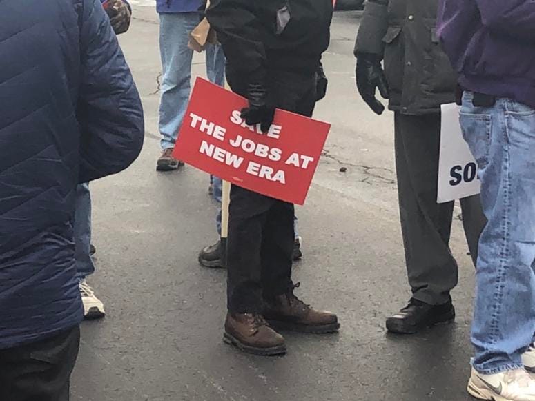 Protesters gather outside the New Era plant in Derby to protest the company's decision to lay off workers and move manufacturing elsewhere.