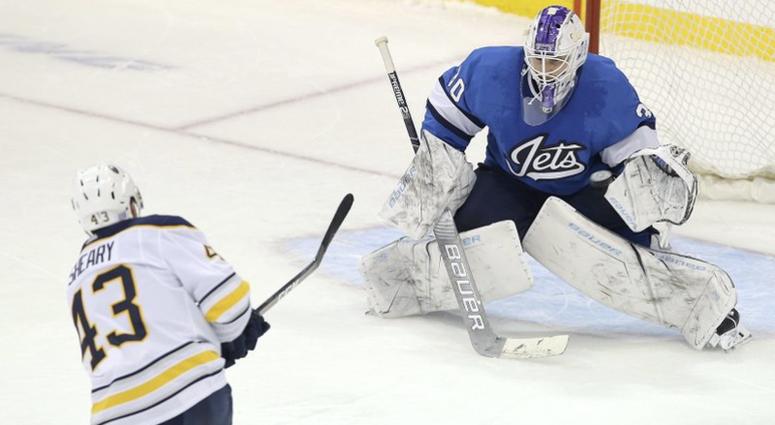 Buffalo Sabres forward Conor Sheary (43) scores in the shootout against Winnipeg Jets goaltender Laurent Brossoit during an NHL hockey game Friday, Nov. 16, 2018, in Winnipeg, Manitoba. (Jason Halstead/The Associated Press via AP)