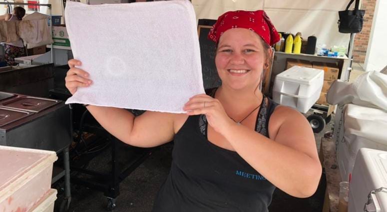 Elise Taft shows off the frozen towel she's using to keep herself cool while working at CanalFest. July 19, 2019 (WBEN Photo/Mike Baggerman)