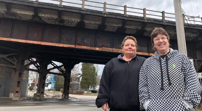 Cheryl Ward (left) and Cindi Barraclough (right) stand in front of the Young Street bridge, where more than 50 trucks became stuck over the last several years, including three in the last three weeks. March 14, 2019 (WBEN Photo/Mike Baggerman)