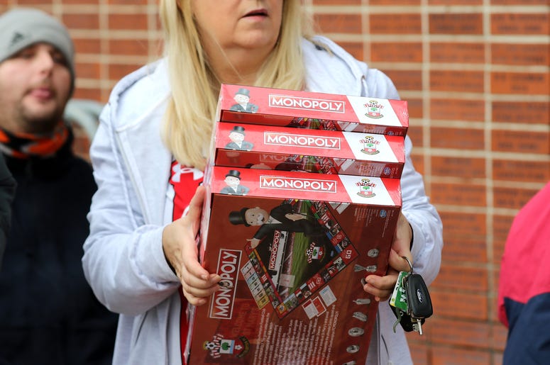 Woman carrying Monopoly games