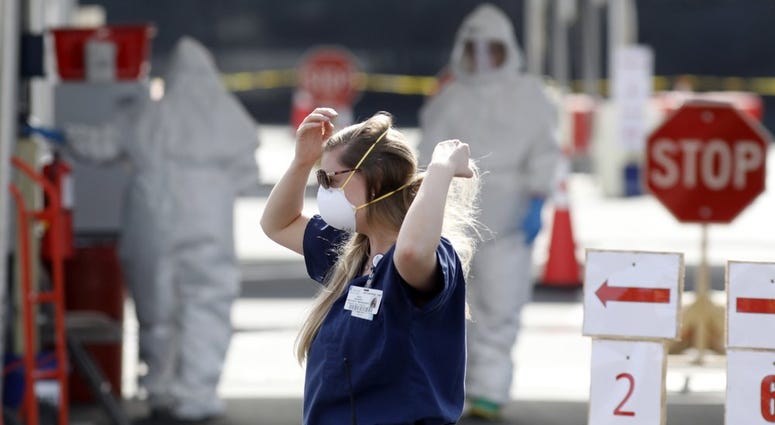 Medical University of South Carolina project manager Amy Jackson adjusts her face mask as healthcare providers dress in protective suiting