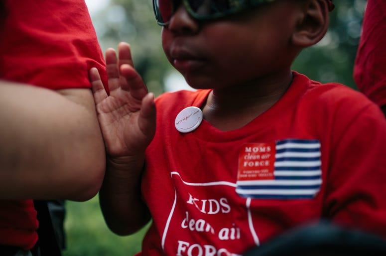 Zion Glover, 3, from Charlotte, N.C., dons a Moms partisan button as he and his mother Nakisa Glover, attend a Moms Clean Air Force rally Zion Glover, 3, from Charlotte, N.C., dons a Moms partisan button as he and his mother Nakisa Glover, attend a Moms Clean Air Force rally