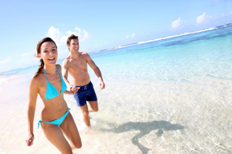 A man and woman in bathing suits at the beach