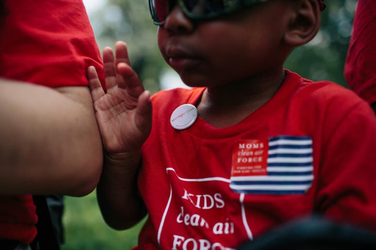 Zion Glover, 3, from Charlotte, N.C., dons a Moms partisan button as he and his mother Nakisa Glover, attend a Moms Clean Air Force rally Zion Glover, 3, from Charlotte, N.C., dons a Moms partisan button as he and his mother Nakisa Glover, attend a Moms Clean Air Force rally