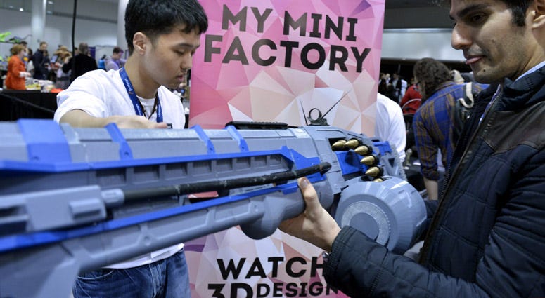 A visitor looks at a 3D printed simulated gun at the 3D Print Design Show. 3D-Printed Guns