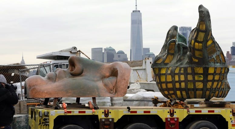 The original torch of the Statue of Liberty, and a replica of her face, rest on a hydraulically stabilized transporter, Thursday, Nov. 15, 2018 in New York. Statue of Liberty