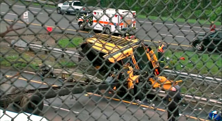 This image taken from WABC-TV video shows an overturned school bus after it collided with a dump truck, injuring multiple people, on Interstate 80 in Mount Olive, N.J., Thursday, May 17, 2018. Deadly New Jersey School Bus Crash