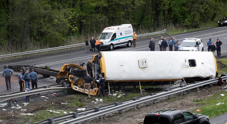 Emergency personnel examine a school bus after it collided with a dump truck, injuring multiple people, on Interstate 80 in Mount Olive, N.J., Thursday, May 17, 2018. Deadly New Jersey School Bus Crash