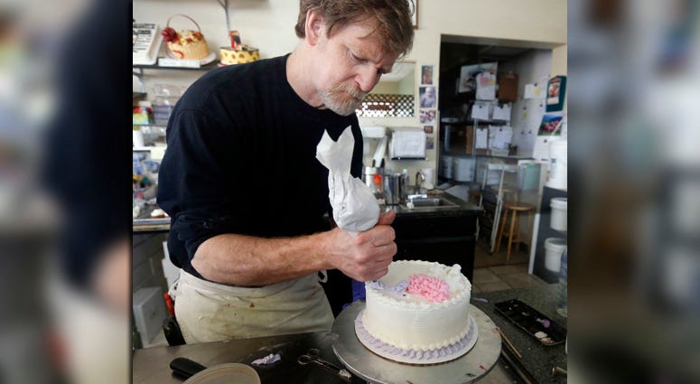 In this March 10, 2014, file photo, Masterpiece Cakeshop owner Jack Phillips decorates a cake inside his store in Lakewood, Colo. Jack Phillips
