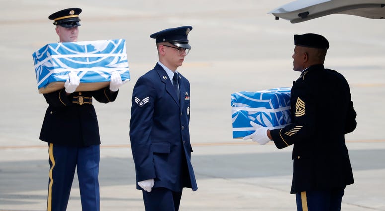 Soldiers carry caskets containing remains of U.S. soldiers North Korea remains