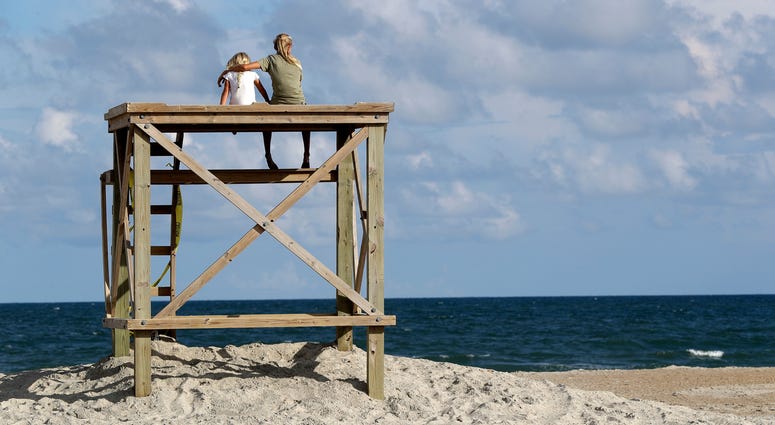 Aubrey Polar, 13, right, of Wilmington, N.C., puts her arm around her sister Sadie Polar, 6, as they look toward the ocean in advance of Hurricane Florence Hurricane Florence