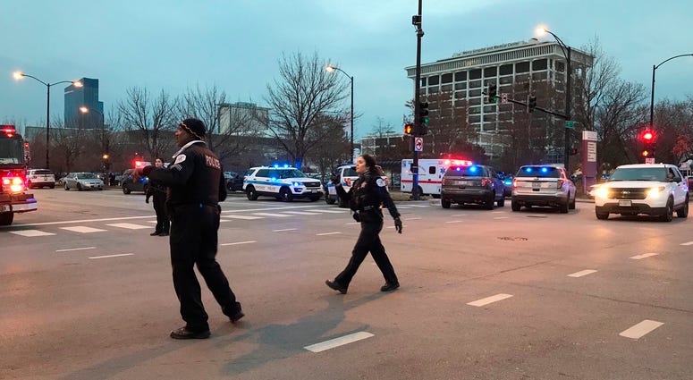 Chicago Police officers walk outside Mercy Hospital on the city's South Side where authorities say a shooting at the hospital has wounded multiple people, including a suspect and a police officer, Monday, Nov. 19, 2018, in Chicago. Chicago Shooting