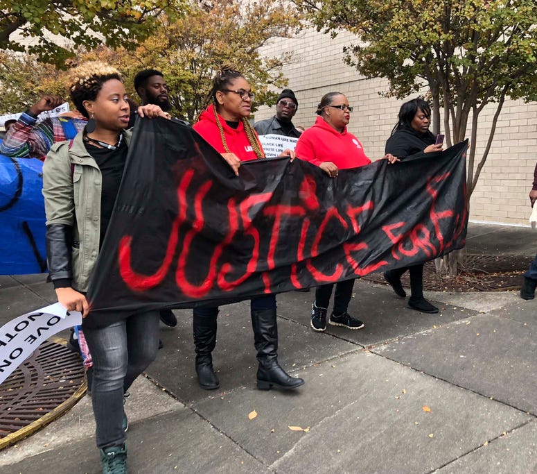 Protestors carry a sign reading “Justice for E.J.” during a protest at the Riverchase Galleria in Hoover, Ala., Saturday, Nov. 24, 2018. Alabama mall shooting