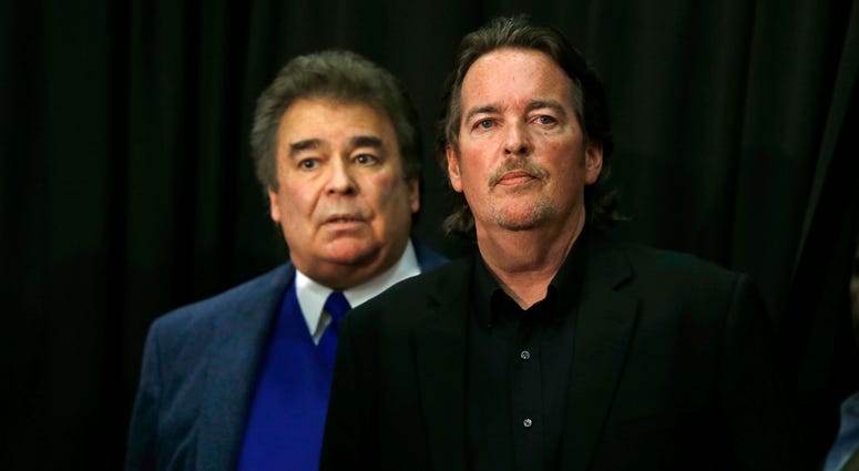 In this April 22, 2016 file photo, Democratic presidential candidate Hillary Clinton's brothers Tony Rodham, right, and Hugh Rodham, stand before she speaks at a campaign stop in Dunmore, Pa. Tony Rodham