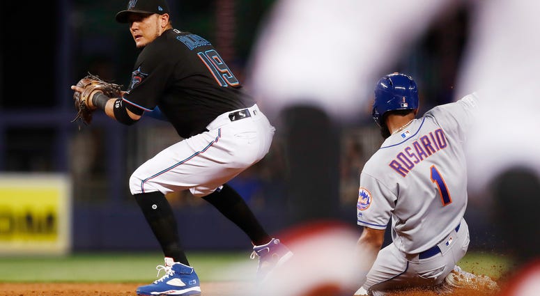 Miami Marlins shortstop Miguel Rojas (19) forces out New York Mets' Amed Rosario (1) at second base during the third inning of a baseball game on Friday, July 12, 2019, in Miami. Mets Marlins