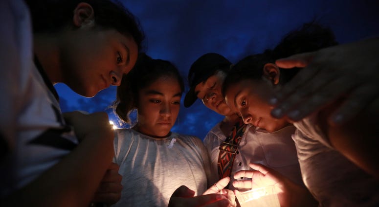 People gather in Juarez, Mexico, Saturday, Aug. 3, 2019, in a vigil for the 3 Mexican nationals who were killed in an El Paso shopping-complex shooting. El Paso shooting