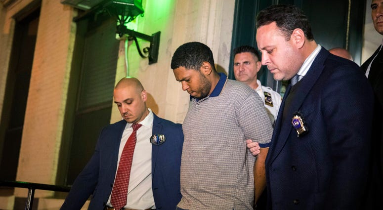 Police officers escort Randy Rodriguez Santos from the 5th Precinct to a vehicle bound for a hospital for evidence collection, Saturday, Oct. 5, 2019, in New York. Randy Rodriguez Santos Chinatown