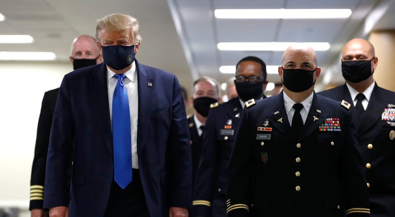 President Donald Trump wears a face mask as he walks down a hallway during a visit to Walter Reed National Military Medical Center in Bethesda, Md., Saturday, July 11, 2020. Trump mask