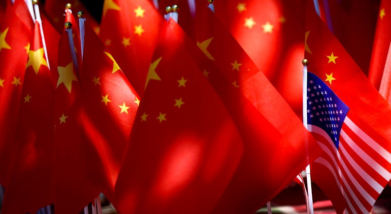 In this Sunday, Sept. 16, 2018, photo, an American flag is displayed together with Chinese flags on top of a trishaw in Beijing. China Tariffs