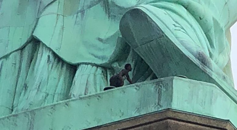 Woman attempting to climb the Statue of Liberty. Statue Of Liberty Climber