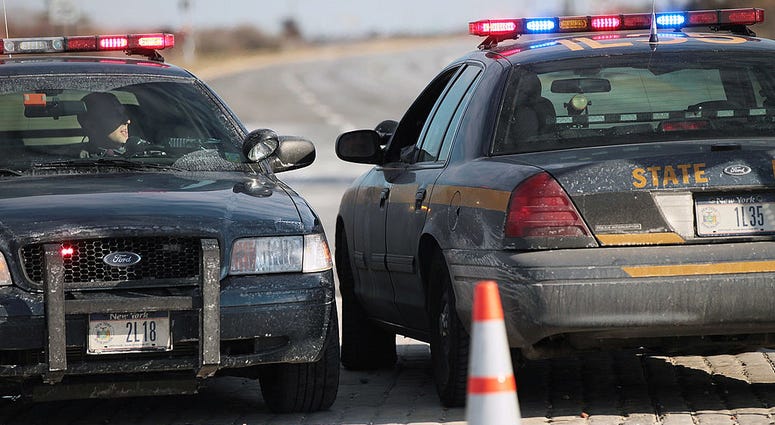 State troopers speak near the location where four bodies were recently found along a quarter-mile stretch of beachside road in New York over the past week December 17, 2010 in Babylon. State Troopers