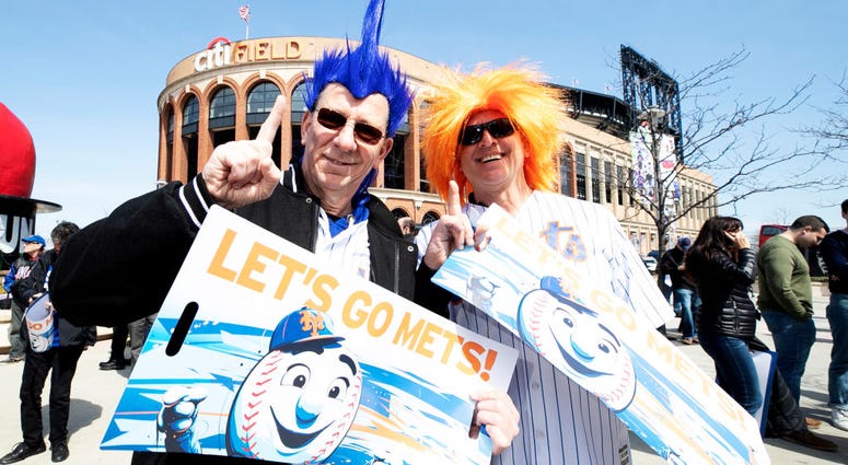New York Mets fans pose for a photo before the home opening game against the Washington Nationals at Citi Field on April 04, 2019 in New York City. New York Mets fans