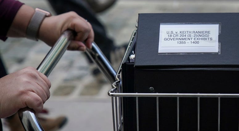Staff and members of the prosecution team push carts full of court documents related to the U.S. v. Keith Raniere case as they arrive at the U.S. District Court for the Eastern District of New York a, May 7, 2019. U.S. v. Keith Raniere