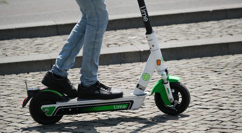A man rides a Lime electric scooter in the city center on June 25, 2019 in Berlin, Germany. Lime scooter