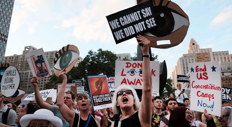 Hundreds of people gather in lower Manhattan for a "Lights for Liberty" protest against migrant detention camps and the impending raids by Immigration and Customs Enforcement (ICE). ICE raid protests