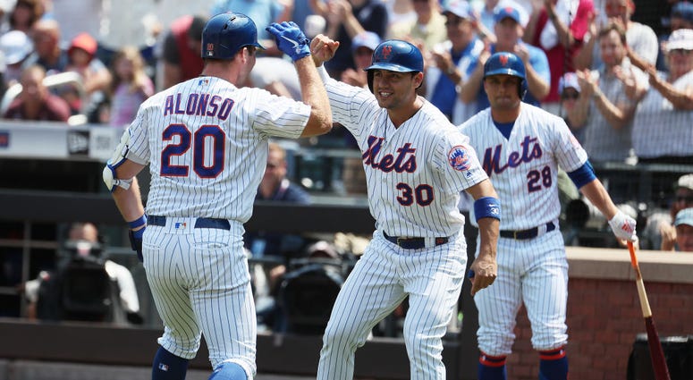 Michael Conforto #30 of the New York Mets meets Pete Alonso #20 of the New York Mets after his two run home run in the first inning against the Miami Marlins during their game at Citi Field on August 07, 2019 Miami Marlins v New York Mets