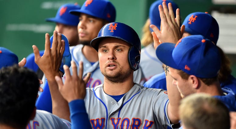 J.D. Davis #28 of the New York Mets celebrates with teammates after scoring on a Michael Conforto single in the third inning against the Kansas City Royals at Kauffman Stadium on August 16, 2019 in Kansas City, Missouri. J.D. Davis