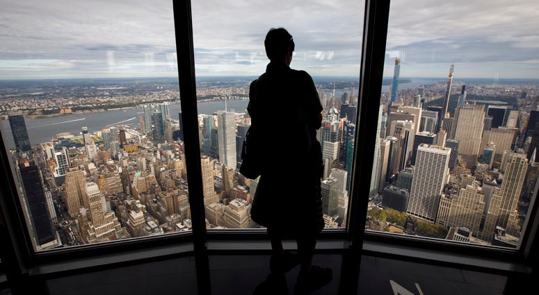 A woman looks out the window toward the West Side of Manhattan inside the newly renovated 102nd floor observatory of the Empire State Building on October 10, 2019. Empire State Building Observatory
