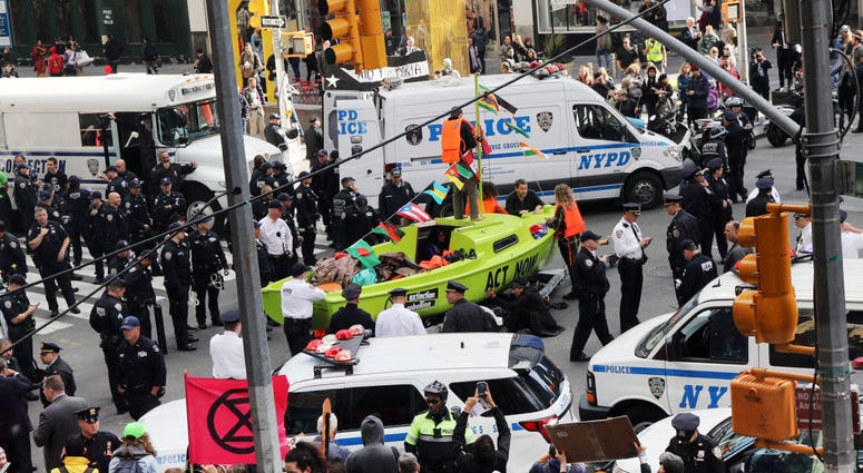 Police gather around a small sailboat that was dropped off in Times Square as part of a protest by the environmental group Extinction Rebellion on October 10, 2019 in New York City. Climate Protesters Times Square