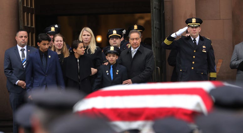 Family members watch as the casket for New Jersey Detective Joseph Seals is brought out of a church during his funeral on December 17, 2019 in Jersey City, New Jersey. Detective Joseph Seals Funeral