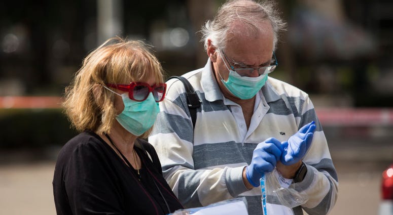Israelis in isolation due to Coronavirus concerns attend to cast their vote in a sterile polling tent on March 2, 2020 in Netanya, Israel. Coronavirus