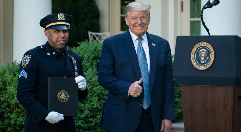 U.S. President Donald Trump poses for a photo with Spencer Garrett, New York City Police Officer, during a Presidential Recognition Ceremony in the Rose Garden of the White House on May 15, 2020 in Washington, DC. President Donald Trump with Spencer Garrett