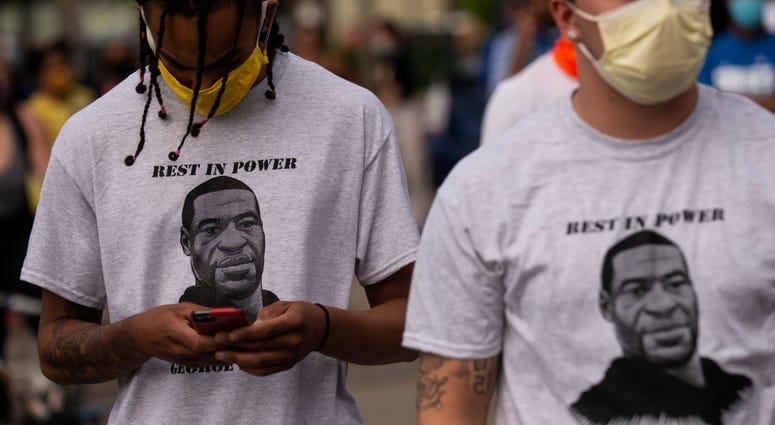 Two men wear shirts stating "Rest in Power George Floyd" outside the Third Police Precinct on May 27, 2020 in Minneapolis, Minnesota. George Floyd protest