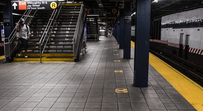 A person arrives to a nearly empty train station during the morning commute hours on the subway in the Brooklyn borough on June 22, 2020 in New York City. NYC subway