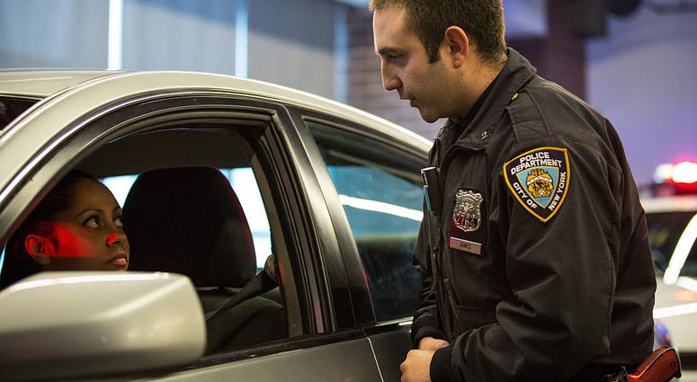 Officer Joshua Jones wears a body camera during a mock traffic stop to demonstrate how the cameras will be used during a press conference on December 3, 2014 NYPD Traffic Stop