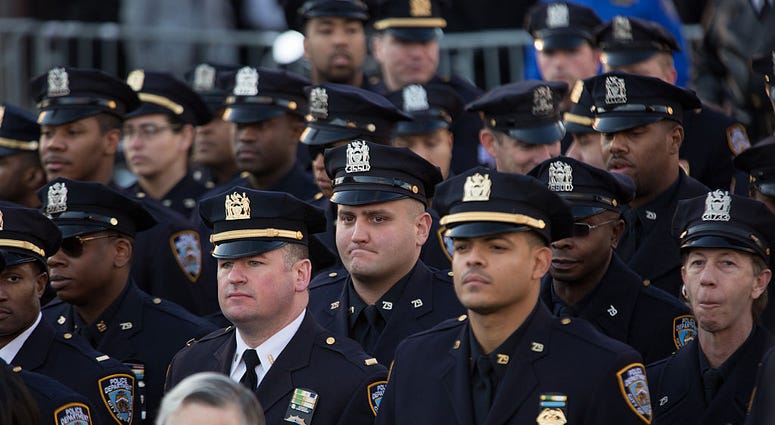 New York Police Department (NYPD) officers from the 79th precinct stand outside before the funeral of slain NYPD officer Rafael Ramos at the Christ Tabernacle Church December 27, 2014 NYPD Officers