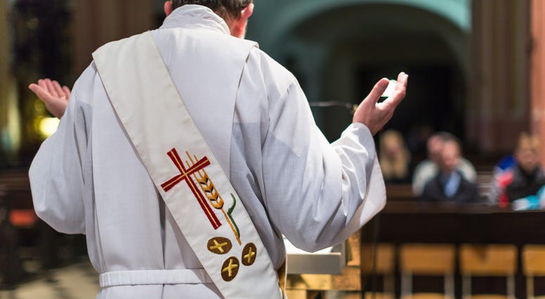 Priest during a ceremony in a church, celebrating a mass. Priest