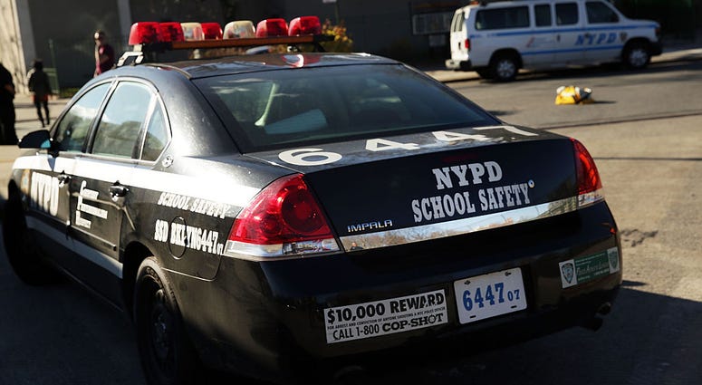 A police car is viewed in front of the Peter Rouget Brooklyn middle school as children are let back in following reports of a bomb threat on December 15, 2015 NYPD School Safety
