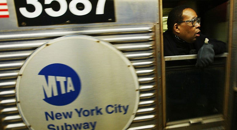 A subway conductor looks out of a window as the train pulls out of a station October 26, 2004 in New York City. Subway Conductor